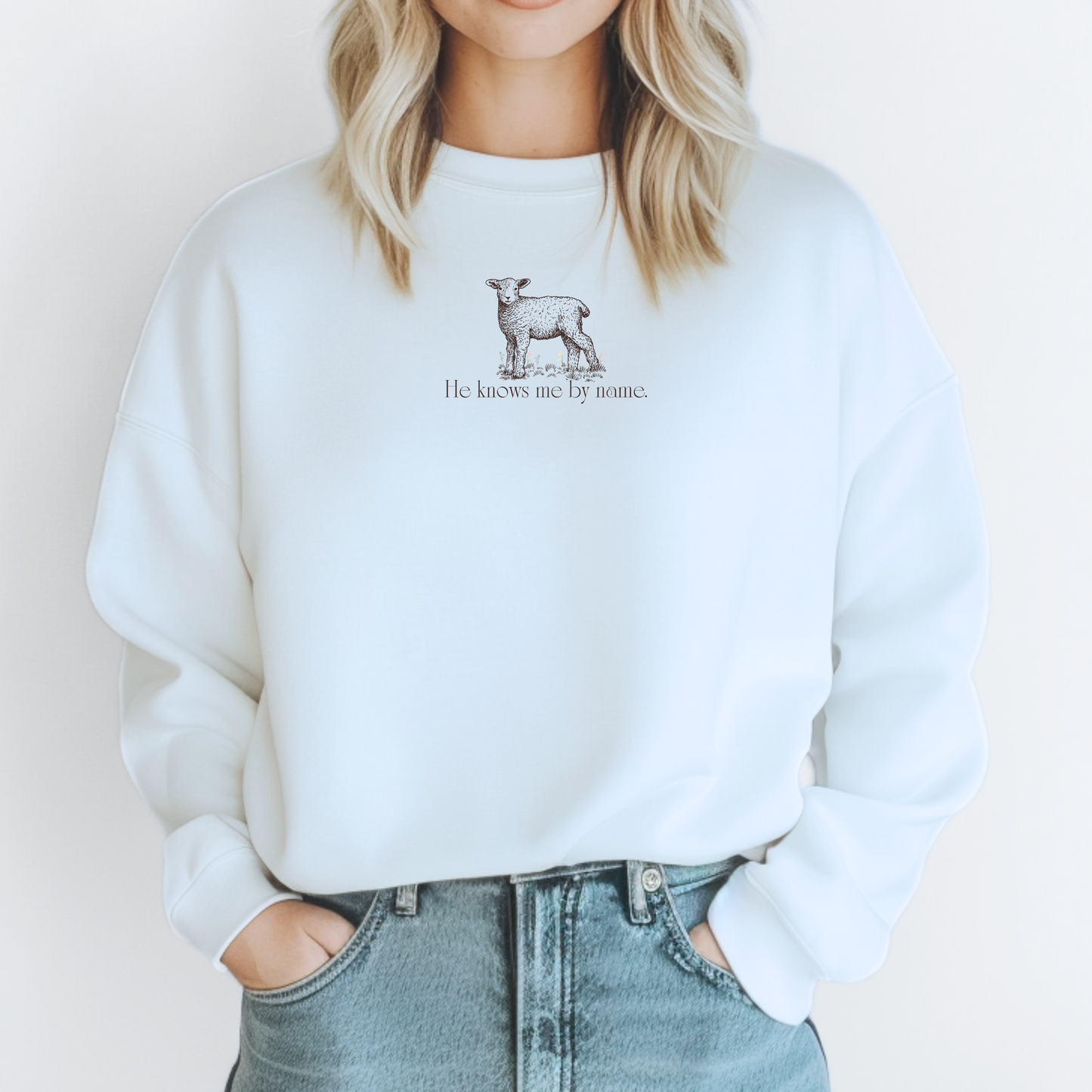 White Christian sweatshirt with lamb graphic and text "He Knows Me By Name" inspired by John 10.
