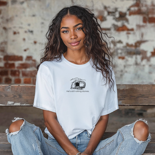 White  unisex Christian t-shirt with stone-rolled-away graphic and text reading "He's still Rolling Stones."