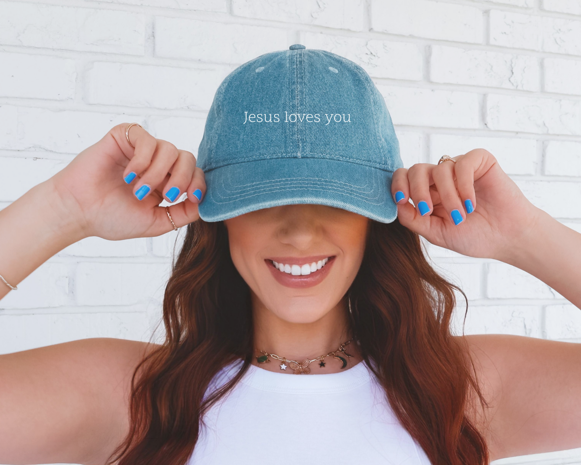 Denim Christian dad hat with embroidered white text saying "Jesus Loves You". 