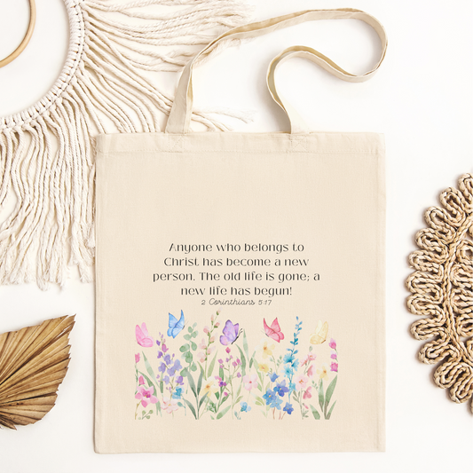 Christian tote bag with butterfly and flower design featuring 2 Corinthians 5:17.. Neutral canvas bag. 