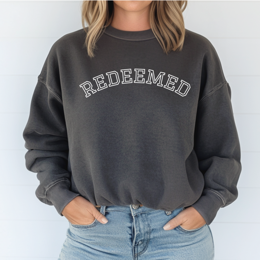 Christian Sweatshirt with text that says "Redeemed" in pepper color. Cozy faith-based sweatshirt. 