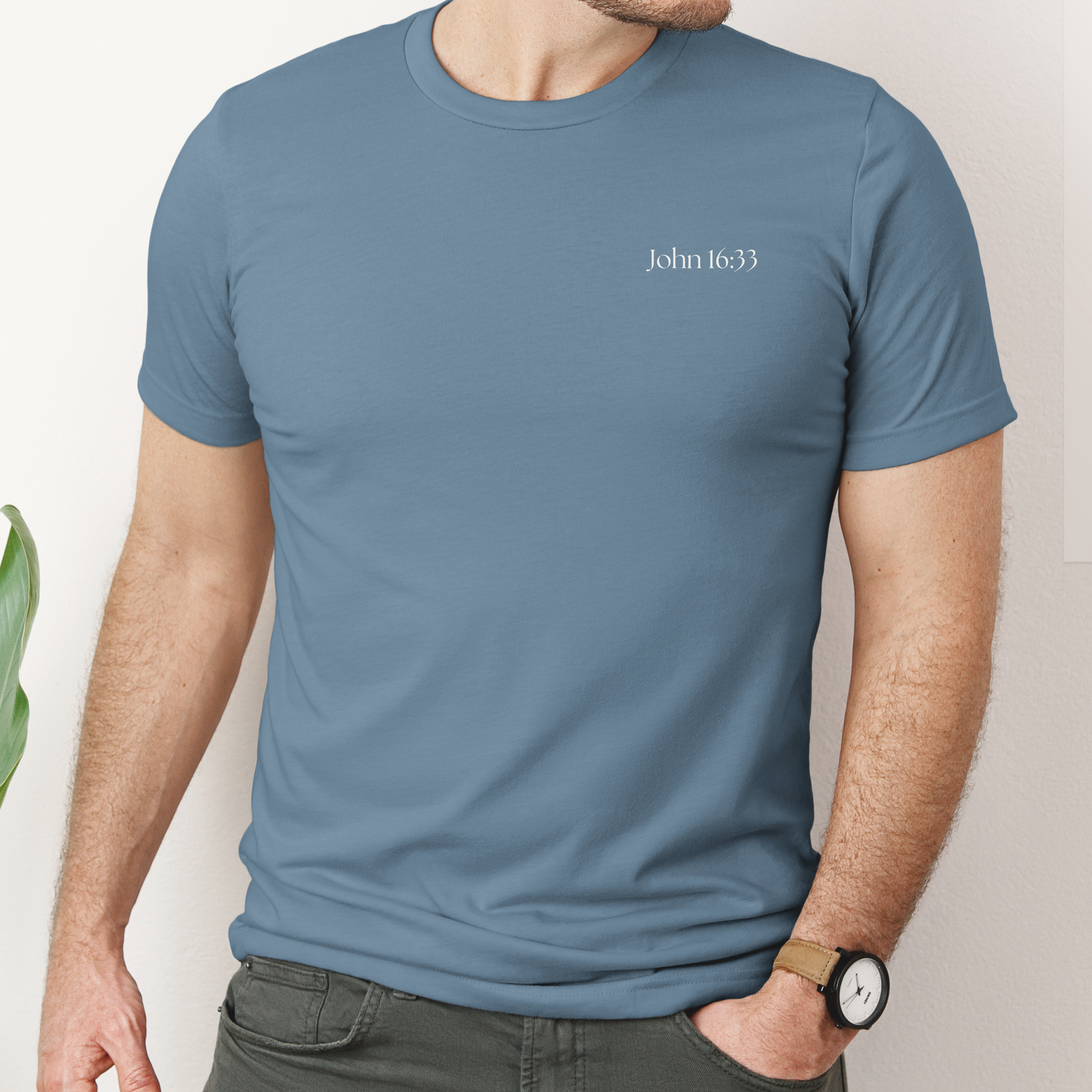 Mens Christian Tshirt in 100% cotton in blue steel color. Bible verse John 16:33 o front and full scripture on back. 